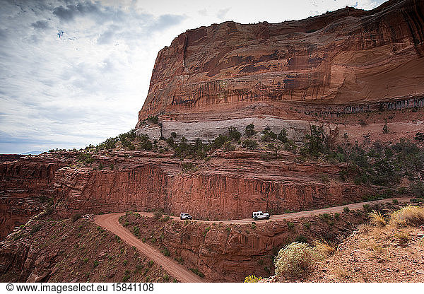 Two vehicles drive Shafer Trail  a 4x4 wheel road  Canyonlands NP
