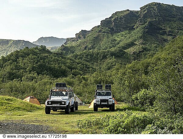 Two white Land Rover off-road vehicles on a campsite with tents  Básar campsite  Þórsmörk Nature Reserve  Suðurland  Iceland  Europe