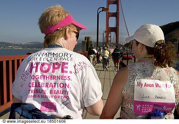 Two women cross the Golden Gate Bridge during a breast cancer walk.