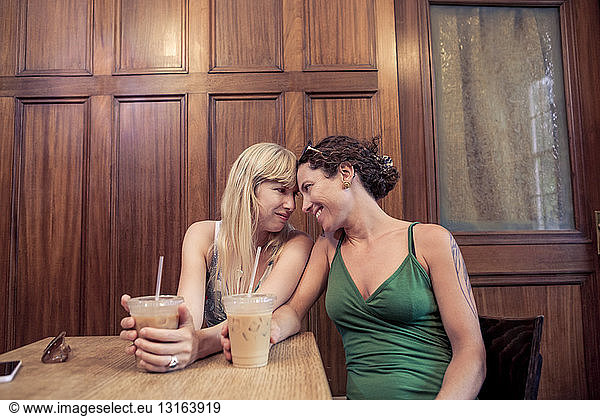 Two women face to face sharing intimacy in cafe