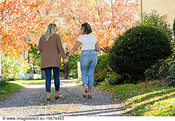 Two women holding hands  walking and looking at each other