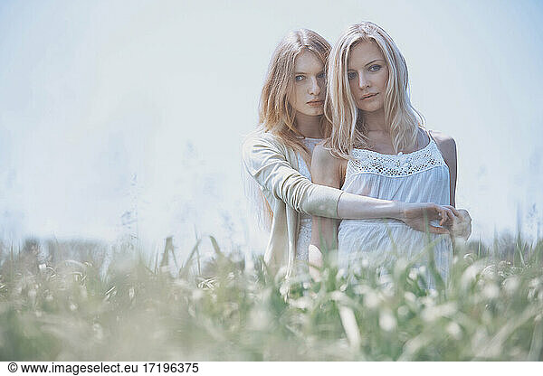 Two women hugging in the grassland. Nicely fits for book cover