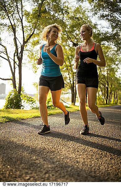Two women jogging together on summer day