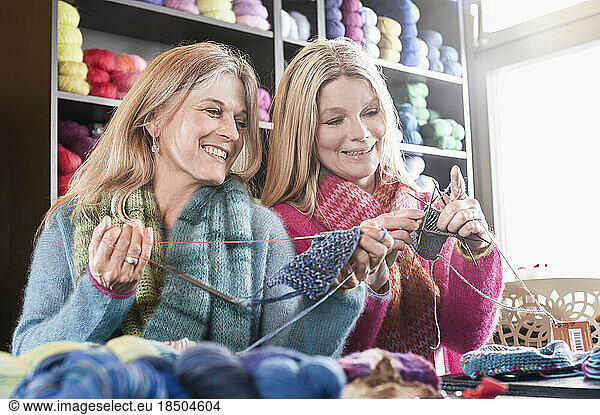 Two women knitting muffler in coffee shop and smiling  Bavaria  Germany