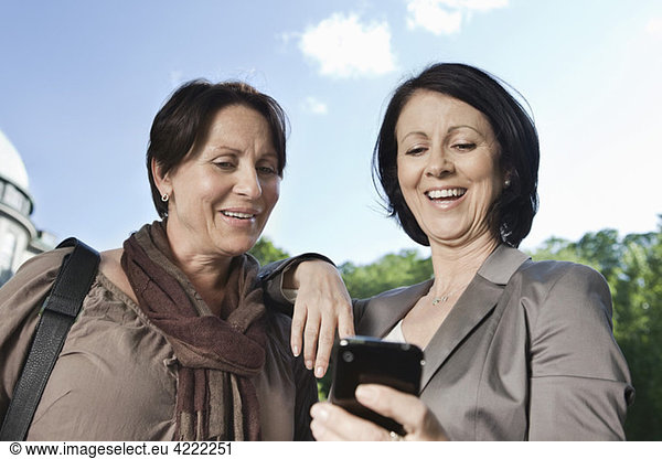 Two women looking at telephone