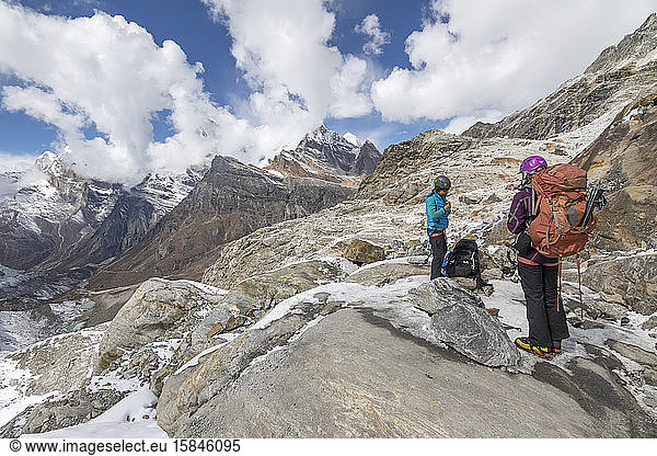 Two women mountaineers get ready to step onto glaciated terrain