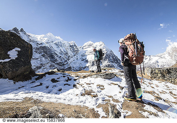 Two women mountaineers take a break among a spectacular mountain scene