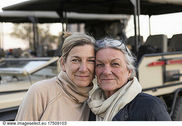 Two women side by side by a safari vehicle  adult woman and her mother  family likeness
