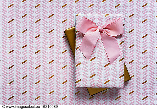 Two wrapped gifts against wrapping paper background