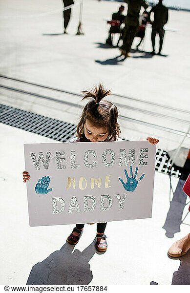 Two Year Old Daughter Holding Sign for Military Dad's Return