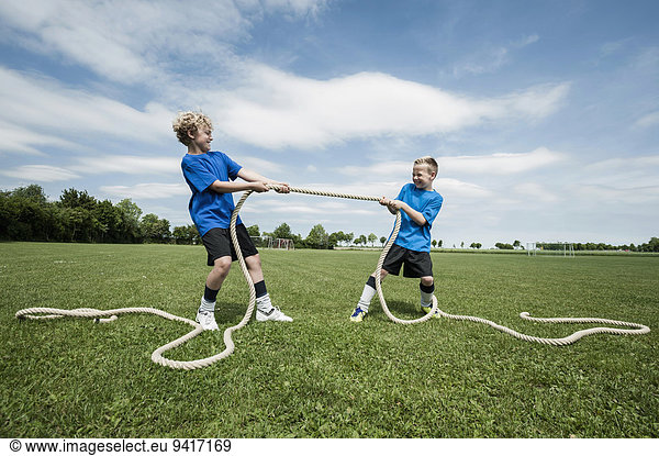 Two young boys practicing Tug-of-war strength