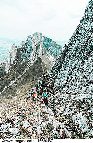 Two young female climber ascending steep mountain face in Switzerland