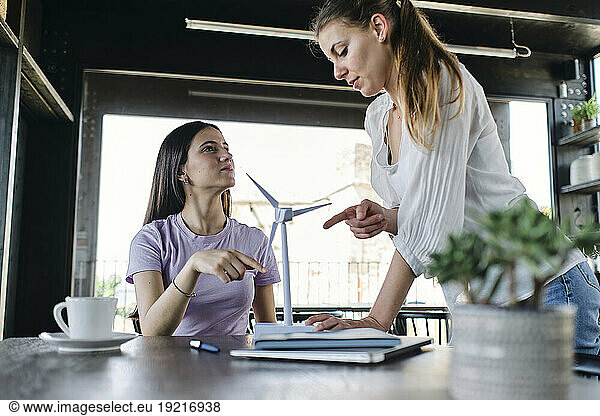 Two young female engineers talking at cowrking space