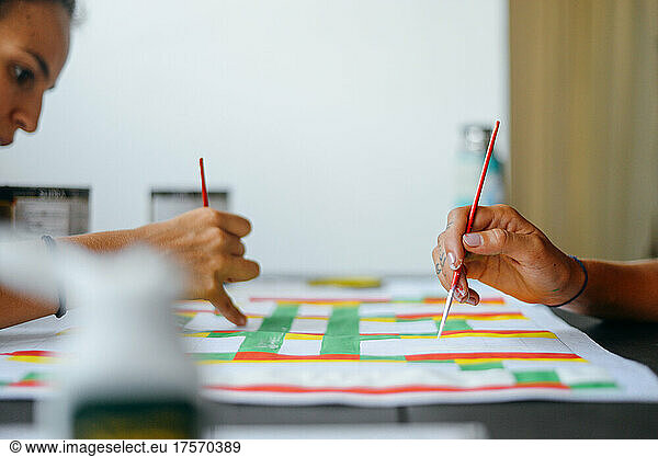 Two young girls painting with colors
