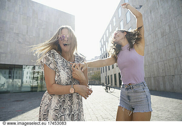 two young happy women dancing in the city of Munich