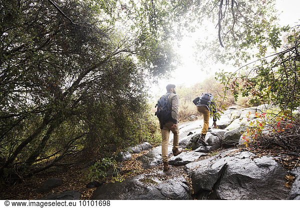 Two young men carrying backpacks hiking.
