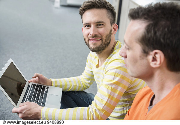 Two young men office portrait planning laptop