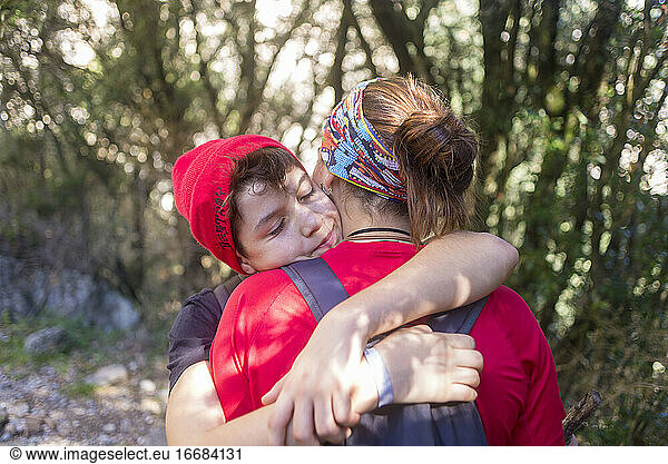 Two young people hugging outdoors in a forest