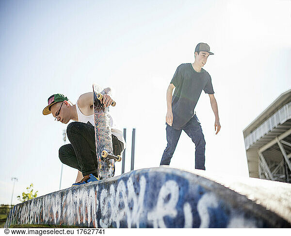 Two young people skateboarding  at a skate park.