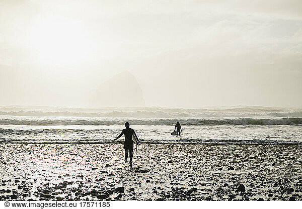 Two young surfers paddling out to catch waves is Coastal Oregon