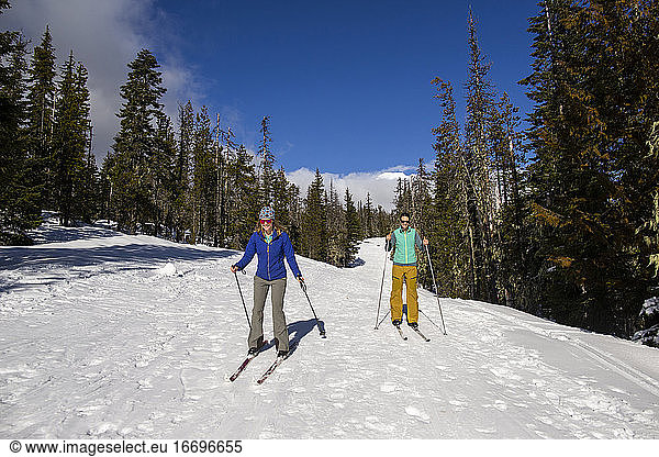 Two young women cross-country ski on Mt. Hood on a sunny day.