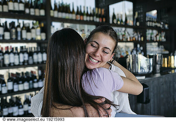 Two young women embracing in bar