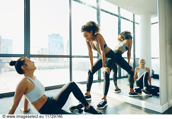 Two young women in gym  taking a break from workout
