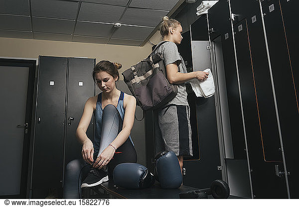 Two young women in locker room of a boxing club