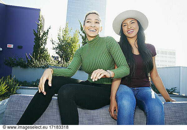 Two young women on a rooftop posing for photographs