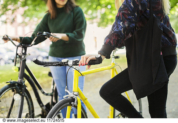 Two young women with bicycles