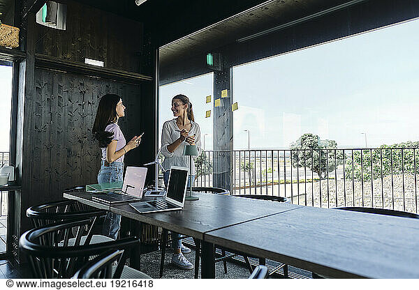 Two young women working together on sustanable resources project at coworking space