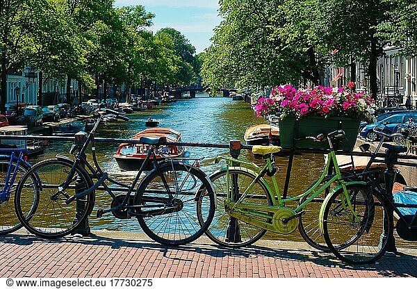 Typical Amsterdam view  Amsterdam canal with boats and bicycles on a bridge with flowers. Amsterdam  Netherlands