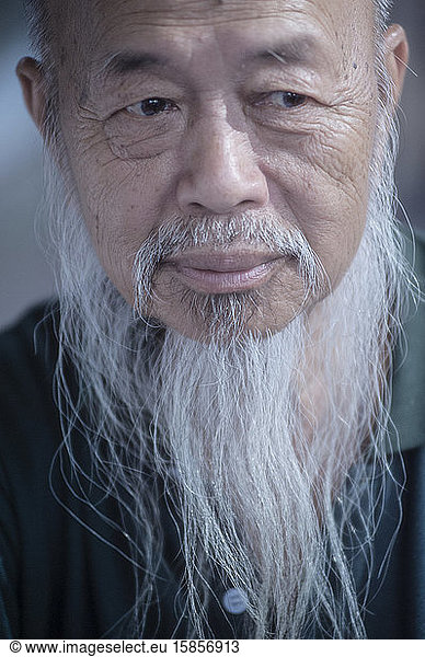 Typical Thai man with long white beard looking away