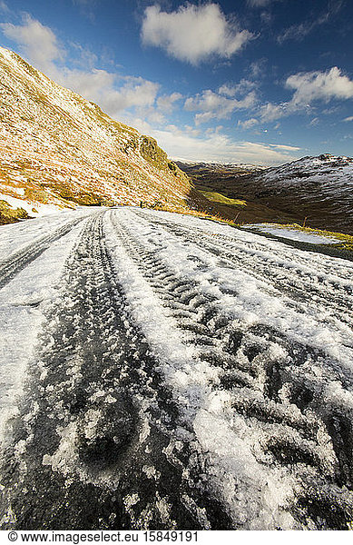 Tyre tracks on Wrynose Pass which was closed by snow and ice  Lake District  UK