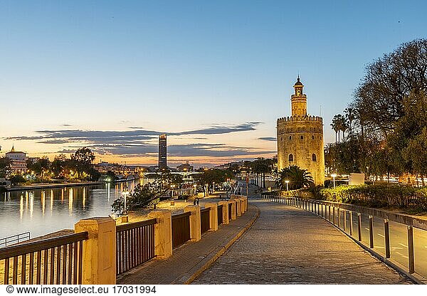 Uferpromenade am Fluss Rio Guadalquivir mit beleuchtetem Torre del Oro  hinten Torre Sevilla  Sonnenuntergang  blaue Stunde  Sevilla  Andalusien  Spanien  Europa