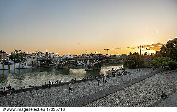 Uferpromenade Muelle de la sal am Fluss Rio Guadalquivir mit Brücke Puente de Triana  Sonnenuntergang  Sevilla  Andalusien  Spanien  Europa