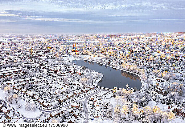 UK  England  Lichfield  Aerial view of lake in snow-covered city at dusk