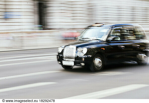 UK  England  London  Blurred motion of taxi driving along city street