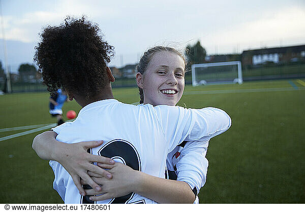 UK  Female soccer team members (10-11  12-13) embracing in field