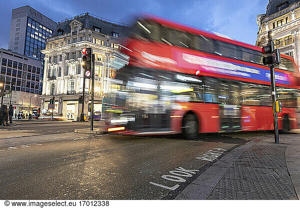 UK  London  Red double decker bus crossing Oxford Circus junction at night  blurred