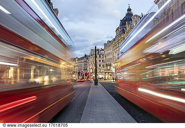 UK  London  Rote Doppeldeckerbusse auf der Oxford Street in der Abenddämmerung  unscharf