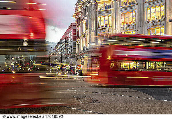UK  London  Roter Doppeldeckerbus überquert Oxford Circus Kreuzung in der Abenddämmerung  unscharf