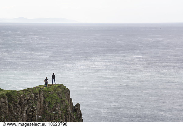 UK  Northern Ireland  County Antrim  people on rock cliff at Causeway Coast