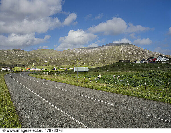UK  Scotland  Empty asphalt road in Outer Hebrides with hills and pastures in background