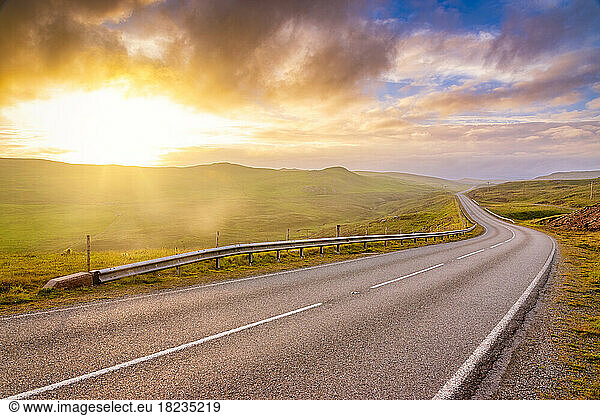 UK  Scotland  Empty asphalt road in Shetland Islands at sunset