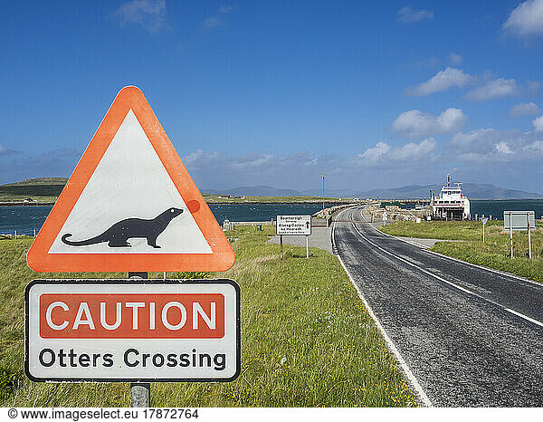 UK  Scotland  Otter crossing sign standing beside asphalt road in Outer Hebrides