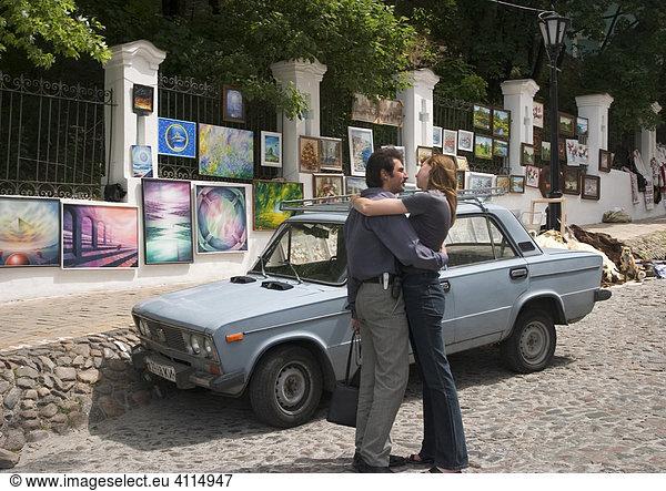 Ukraine Kiev Andrijivskyj Straße Liebespaar umarmt sich vor Auto Bilderaustellung am Straßenrand 2004