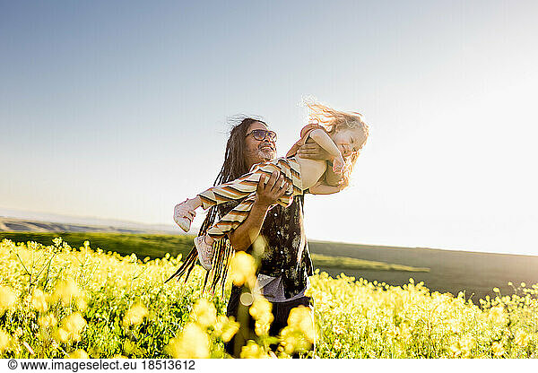 Uncle Holding Niece Up High in Flower Field in San Diego