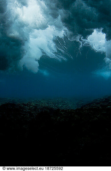 underwater shot of a wave breaking in Fiji  looking like a storm sky