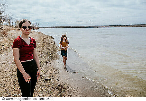 unhappy teen girl standing next to lake